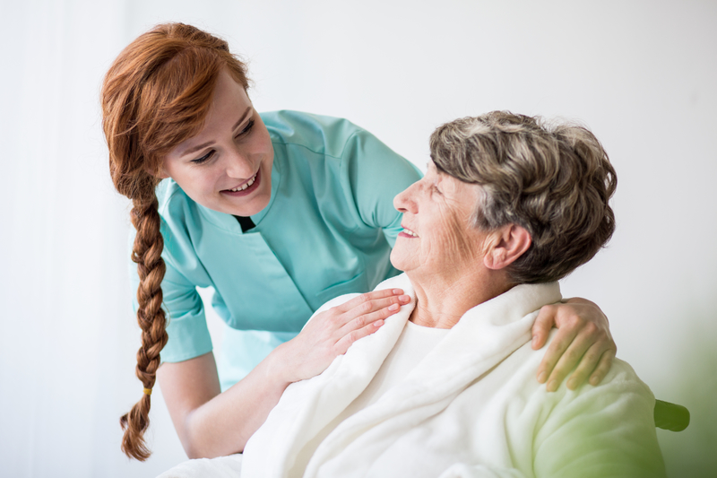 caregiver helping elderly female patient