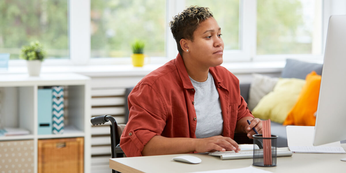 disabled woman using computer - certified neurodiverse financial planning services