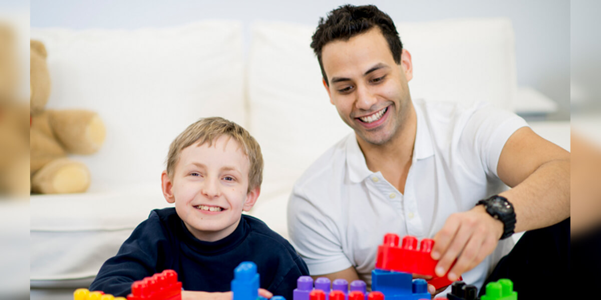 father son playing with plastic blocks - certified neurodiverse financial planning services