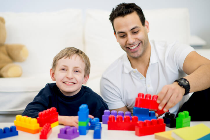father son playing with plastic blocks - certified neurodiverse financial planning services