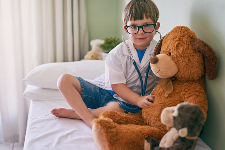 kid playing doctor with teddy bear - neurodiverse autism financial planning services farmington ct