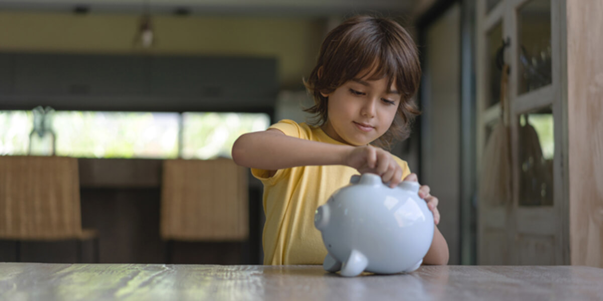 small boy coins in piggy bank - who can open an able able account certified financial planning
